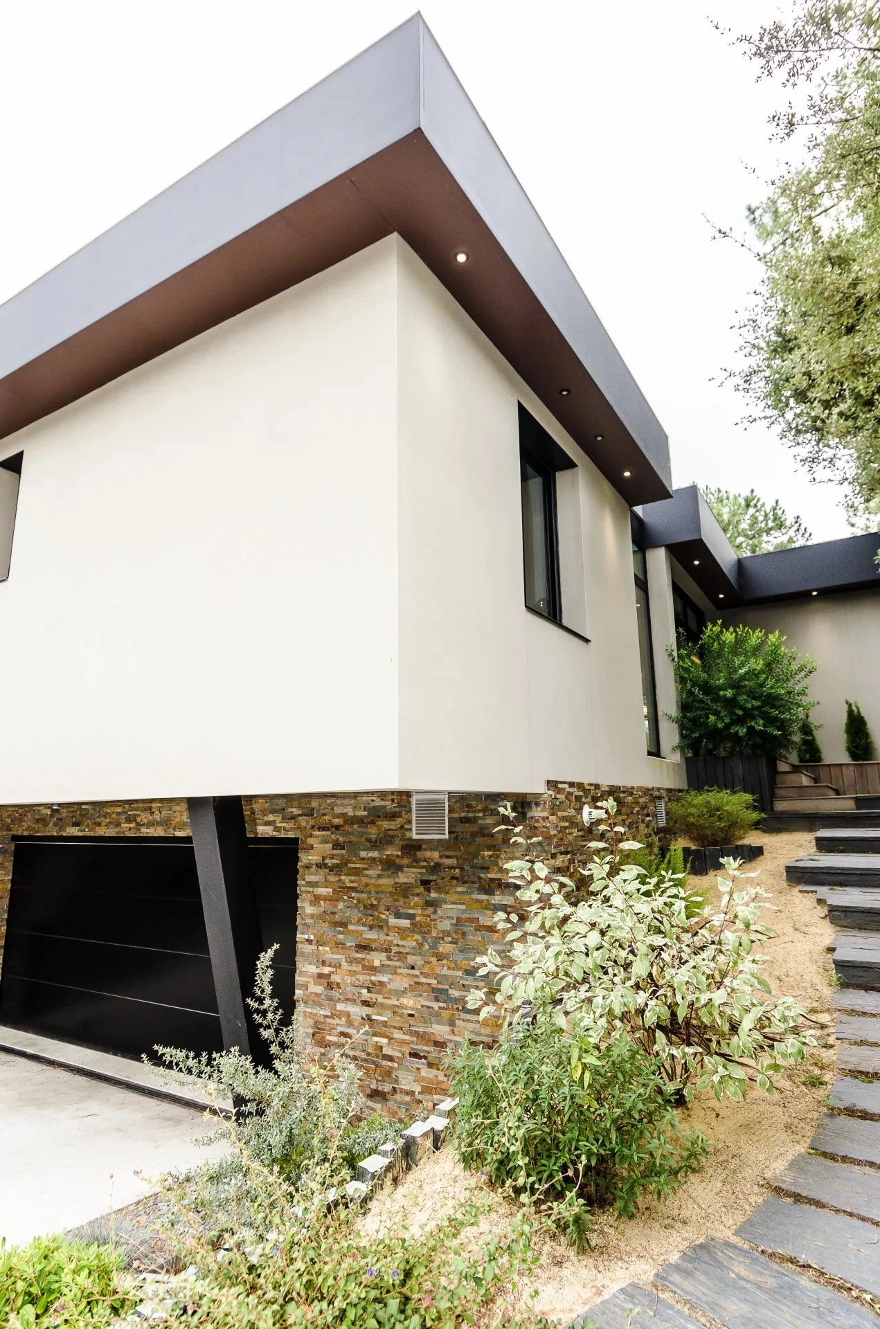 Villa contemporaine à toiture débordante et soubassement en pierre