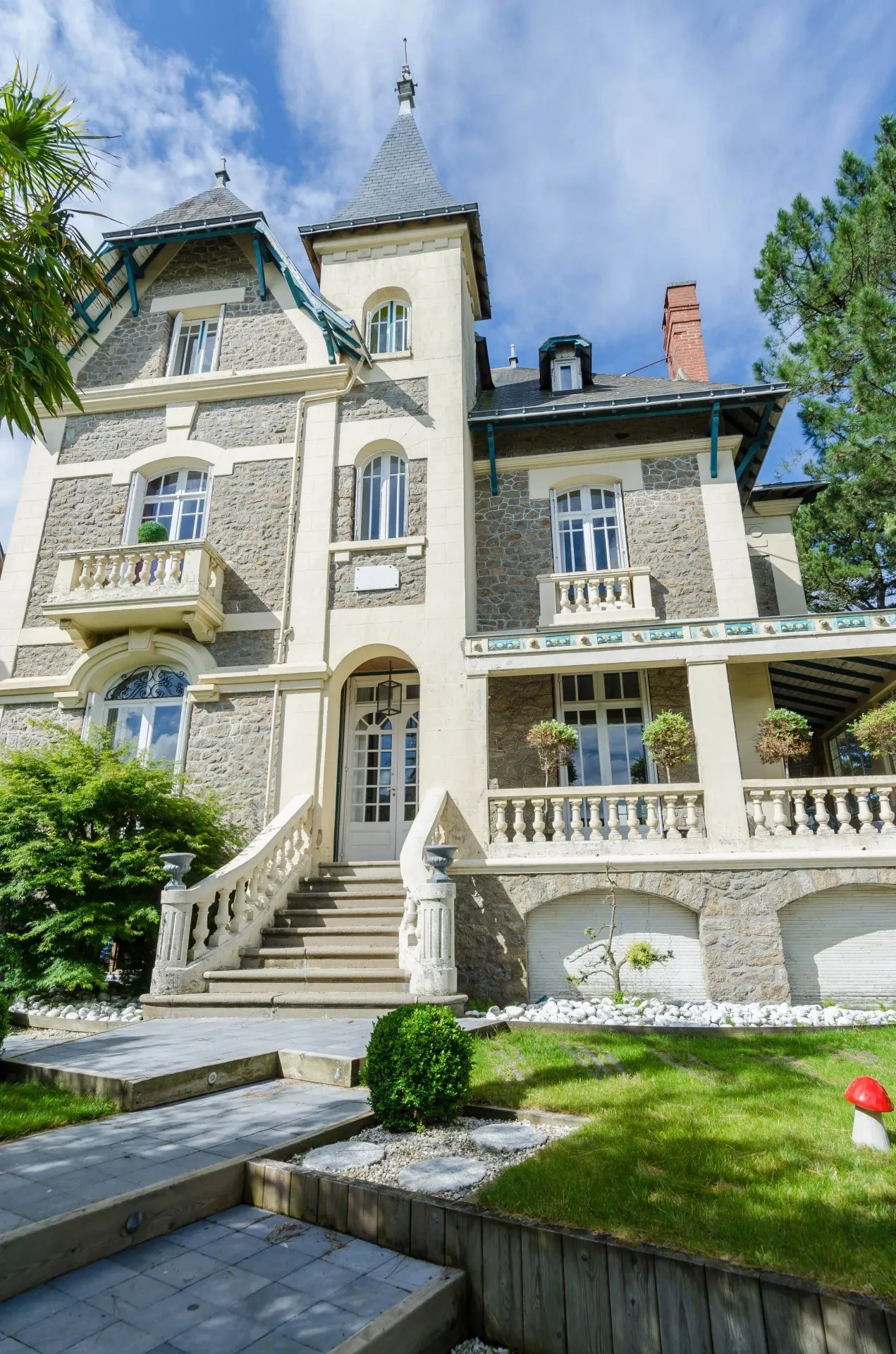 Détail d'une villa en granit avec tourelle et perron à balustres
