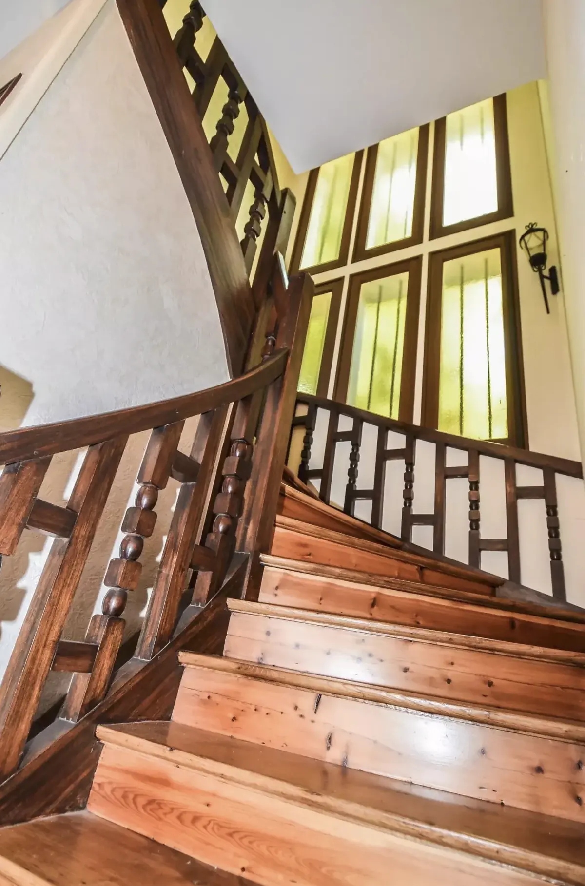 Cage d'escalier de la villa Coq de Roche, triptyque de fenêtres à verre ambré et rampe en bois tourné